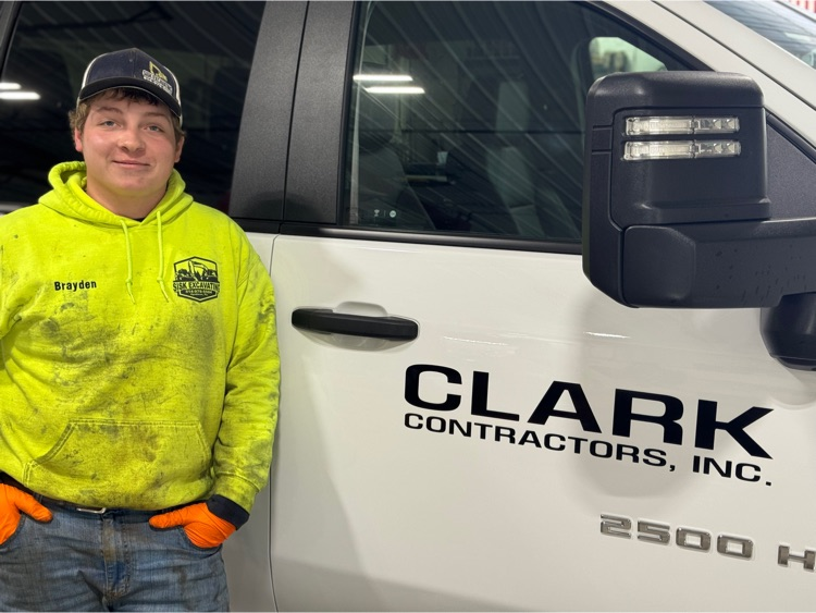 Brayden posing in front of new Clark Contractor truck